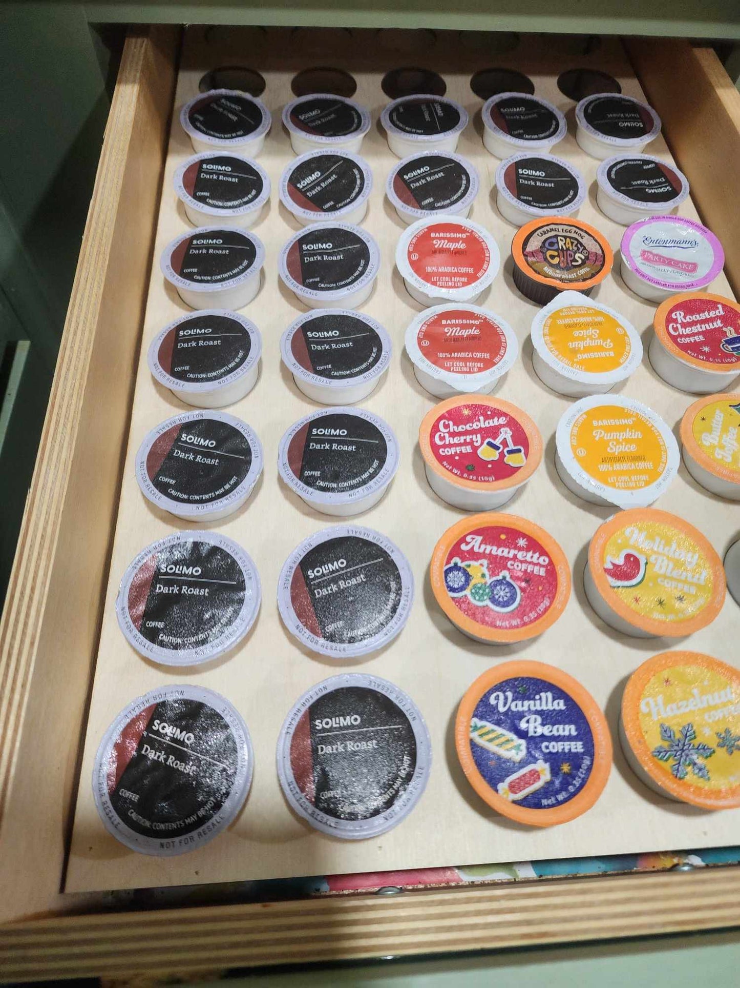 Shows a coffee k cup drawer organizer full of coffee pods