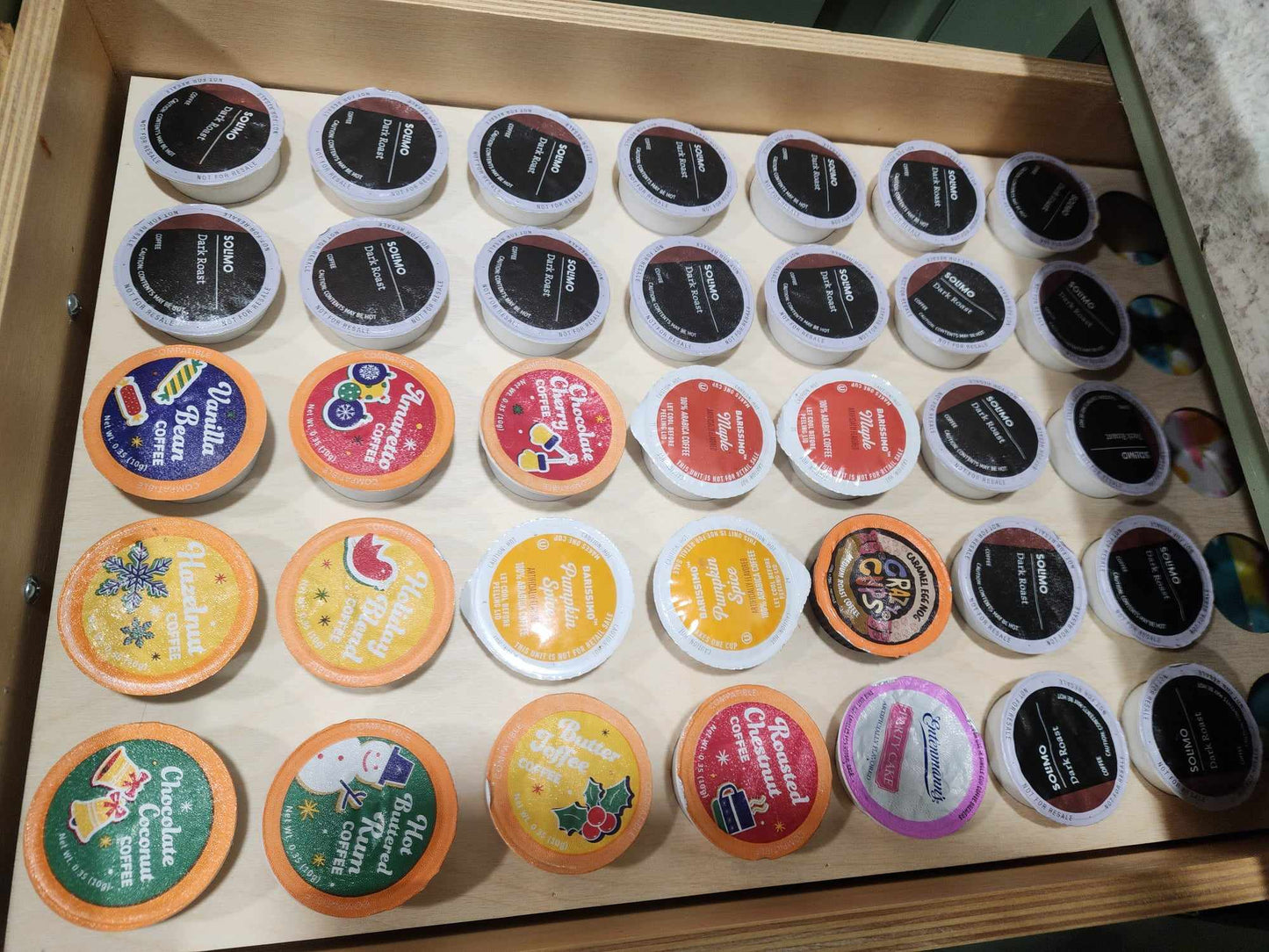 Shows a coffee k cup drawer organizer full of coffee pods